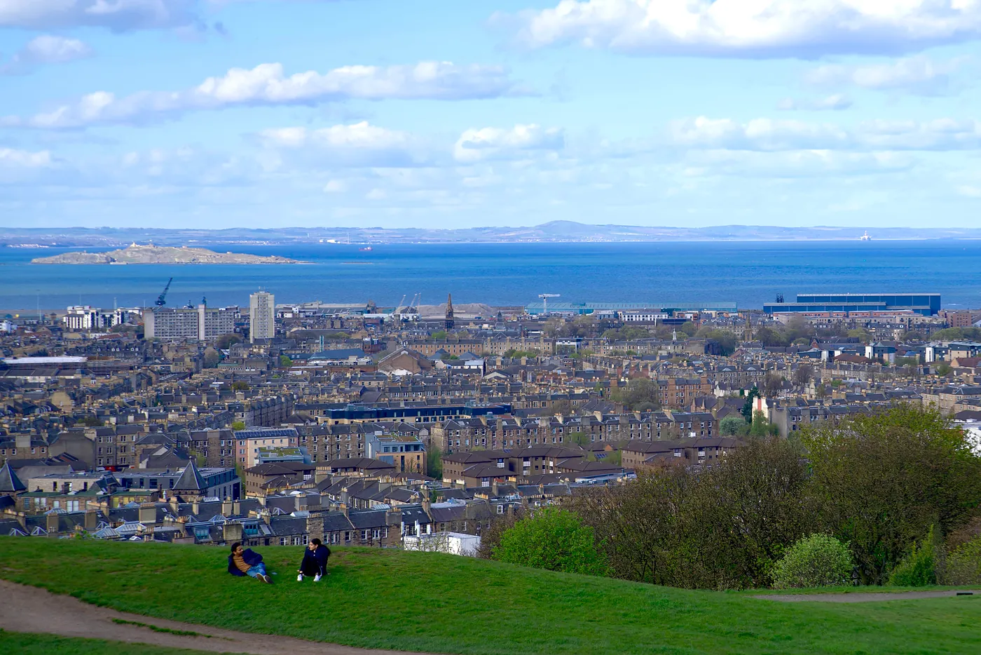 Two friends relaxing with Firth of Firth behind them.