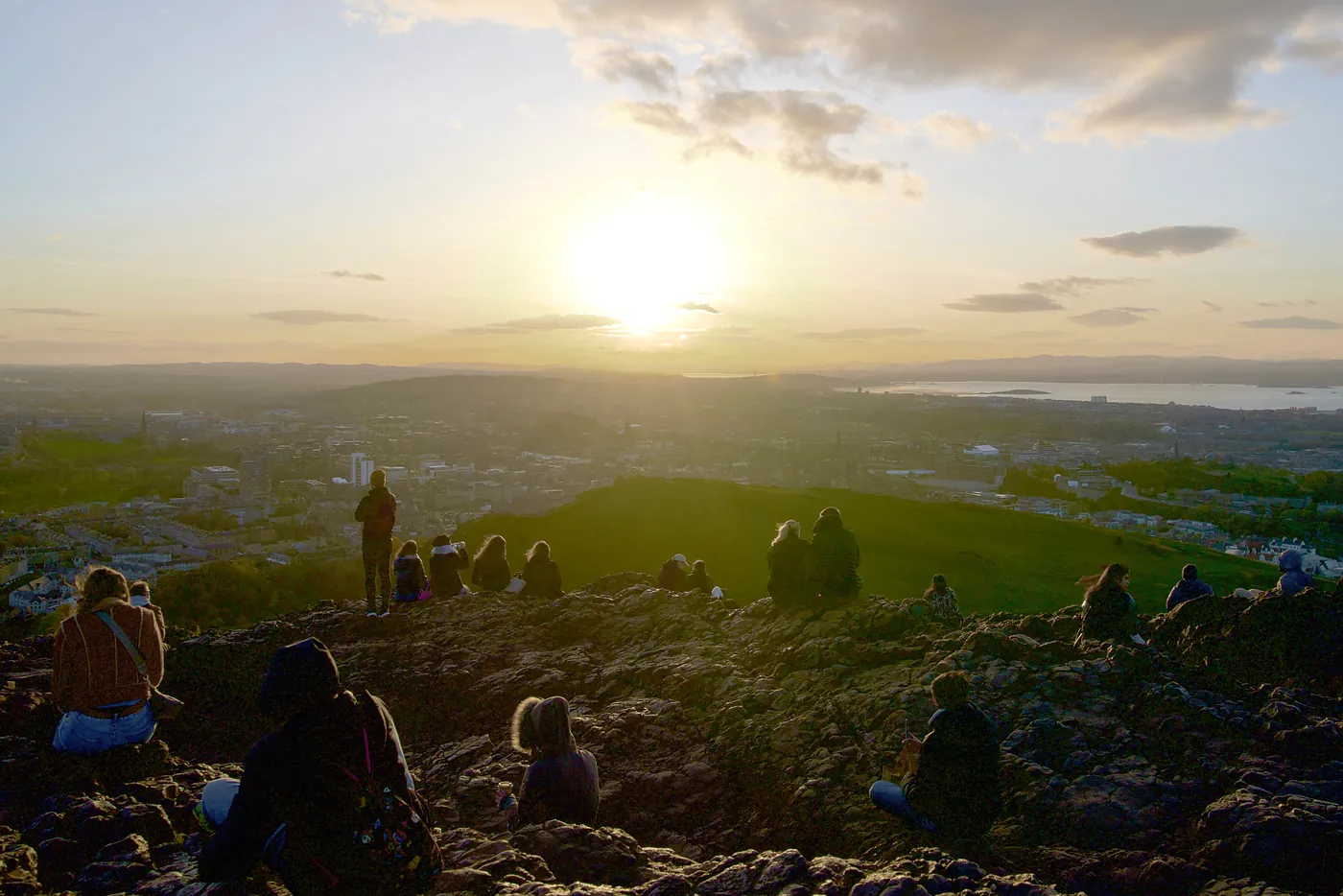 Onlookers watching a sunset over Edinburgh.