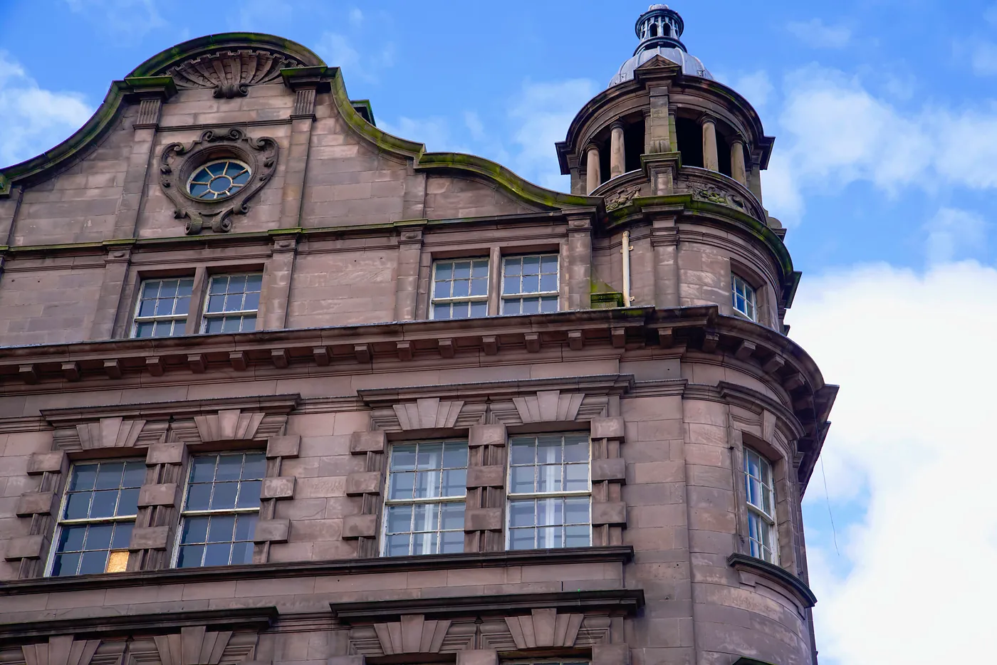The top of a building's façade on the intersection of West End and Prince's Street. The West End is known for its regal, georgian architecture.