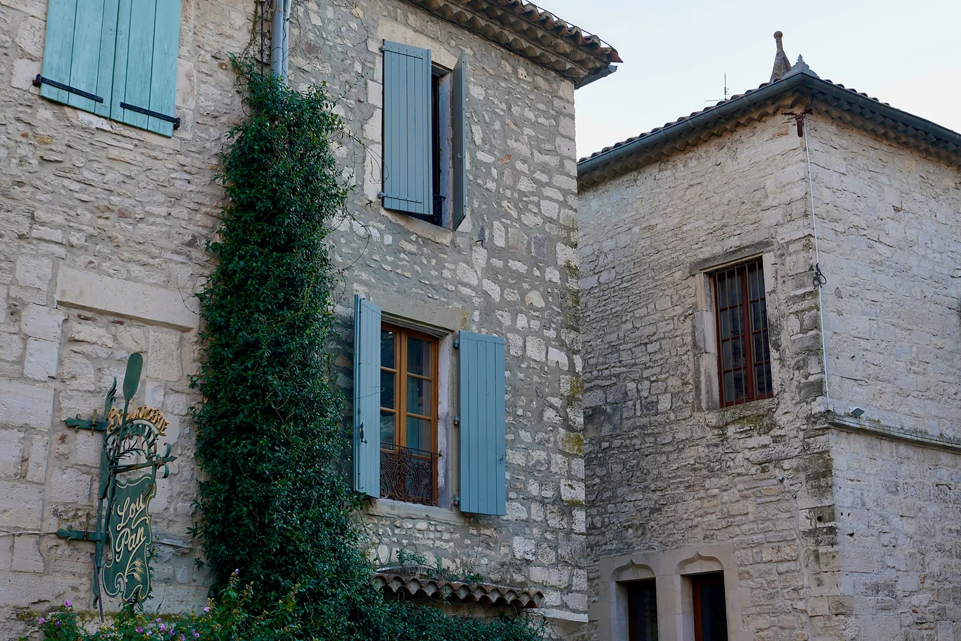 The sides of different buildings on l'Grand Rue. Note the different styles of construction in stonework, window arches, and window panes. These have changed over centuries of existence and repair.
