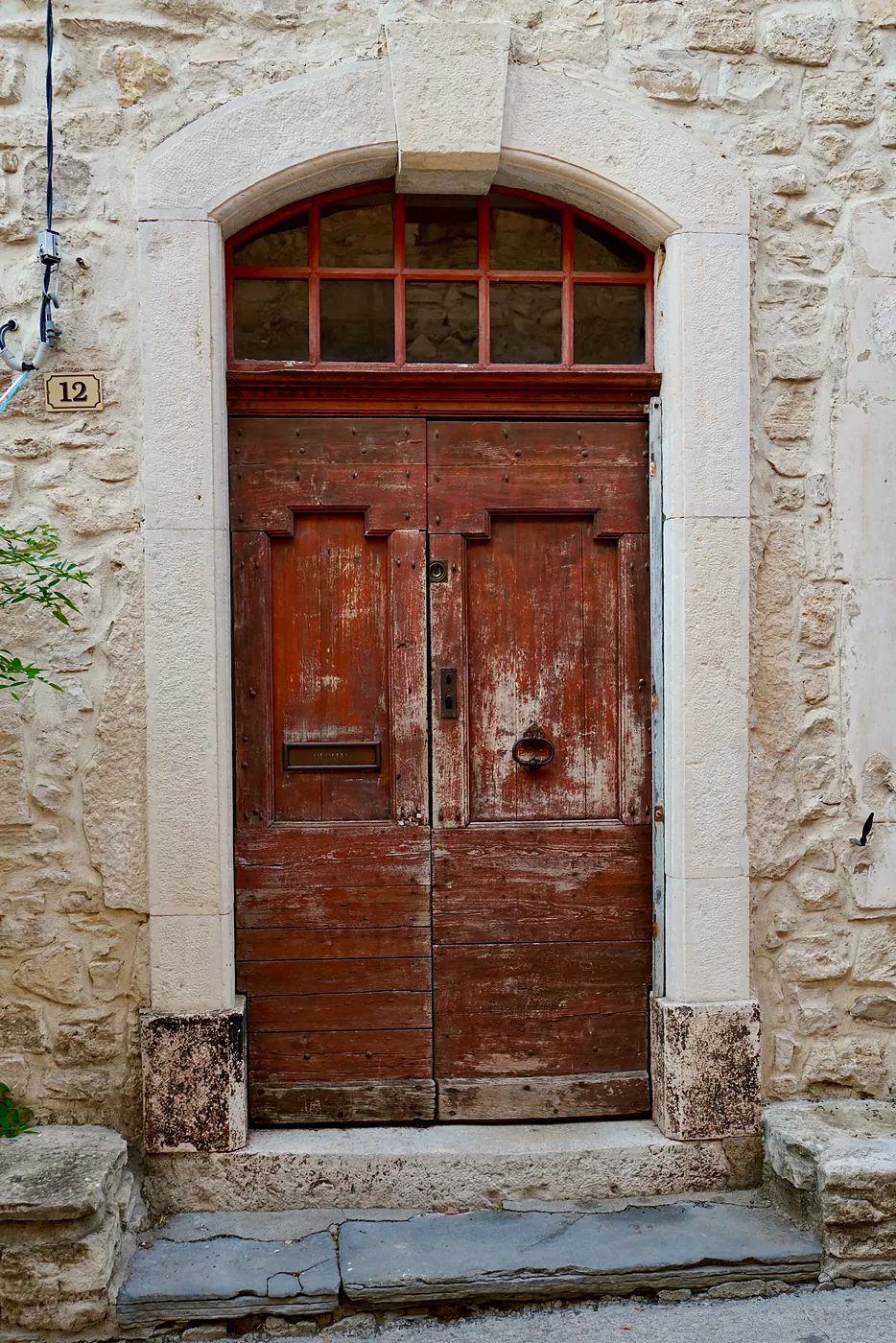An old residential door weathered by many knocks and bruises.