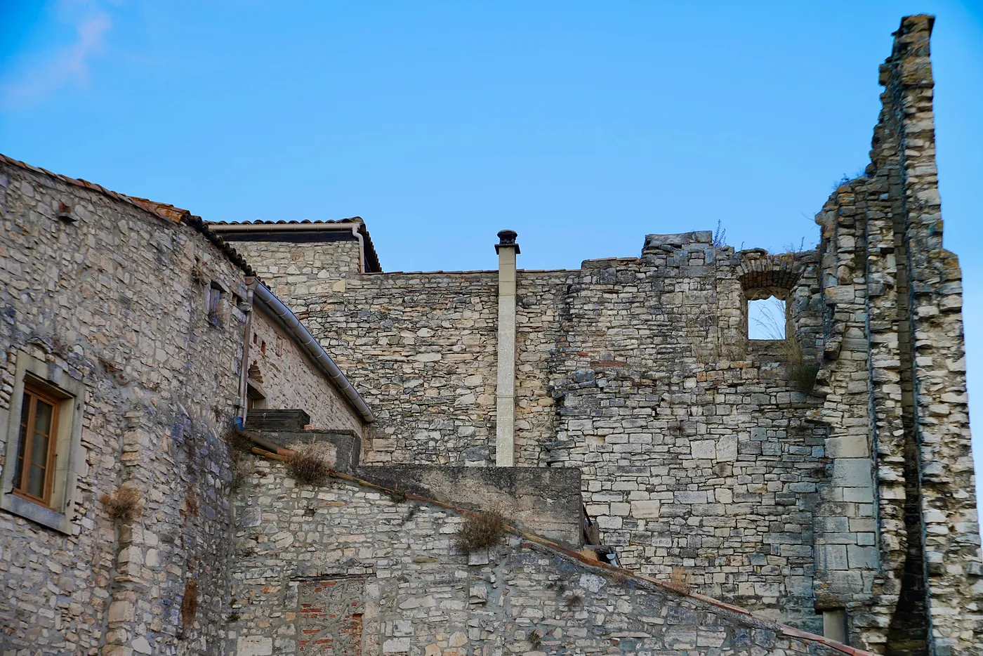Residential houses merging with a large ruined building.