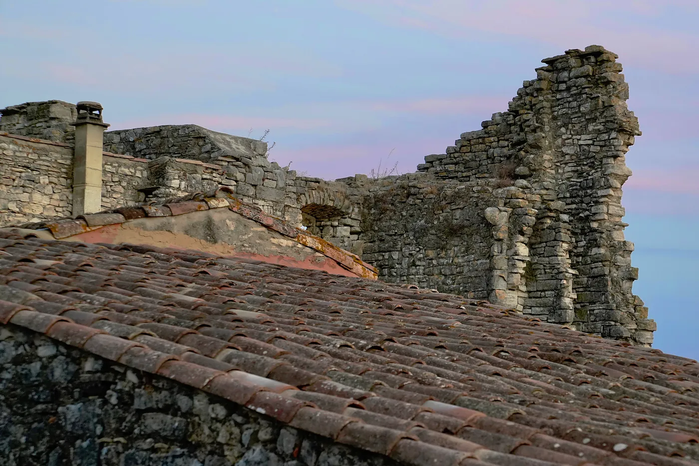 Pink clouds and blue skies behind the ruined building.