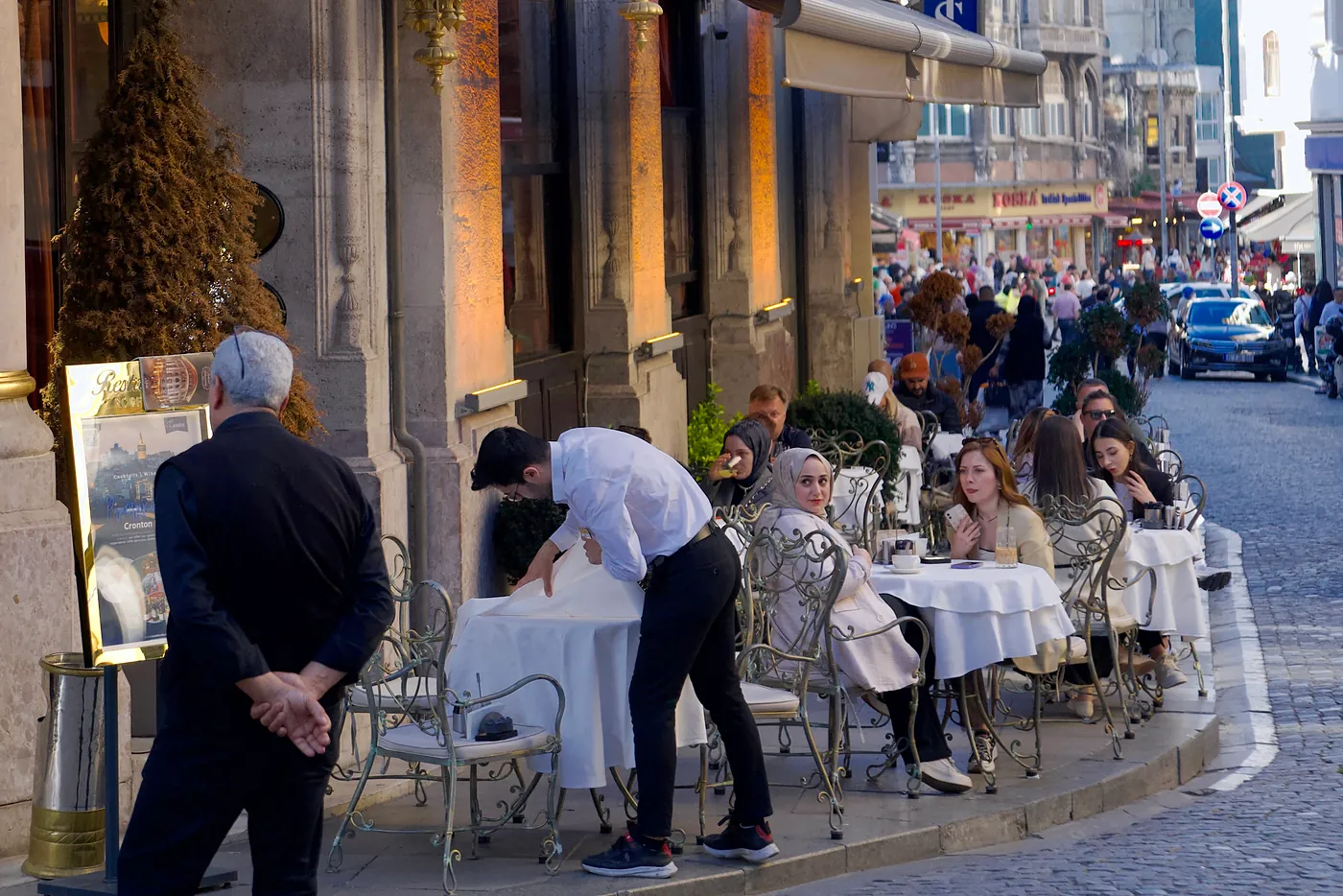 A group of tourists and affluent Turks sipping chai and coffee at the tables of an expensive hotel.