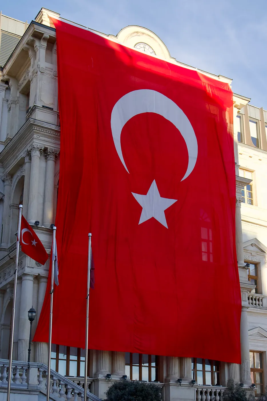 A large Turkish flag draped over a governmental building.