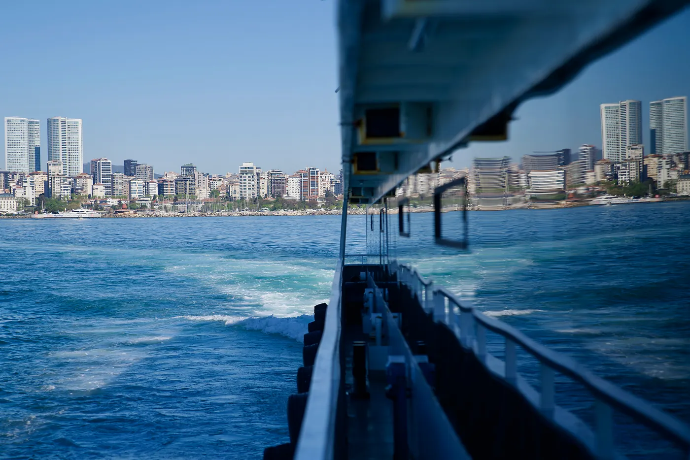 Moda's neighborhood reflected in the windows of a ferry boat.