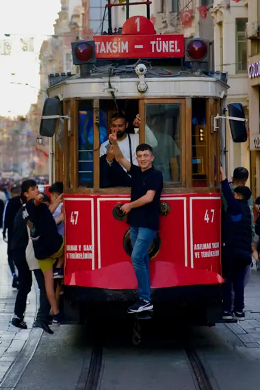 Boys hanging off the red Taksim–Tünel heritage tram on İstiklal Avenue, Istanbul