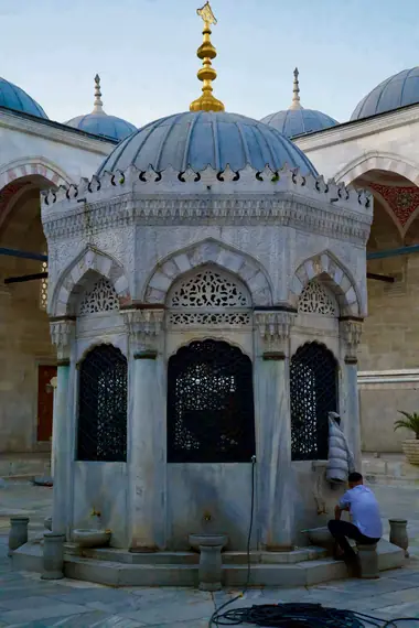 Domed Ottoman ablution fountain with ornate ironwork in a mosque courtyard, Istanbul